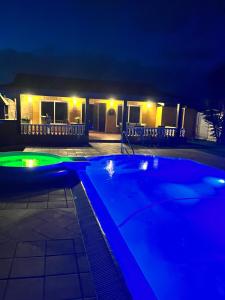 a swimming pool at night with lights on a house at VISTAMALPEI in Cotillo