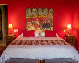 een rode slaapkamer met een groot bed met rode muren bij Casa Don Pascual Hotel Boutique Sweet Home in San Miguel de Allende