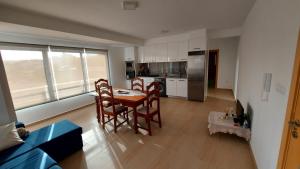 eine Küche mit einem Tisch und Stühlen im Zimmer in der Unterkunft Apartamento F3, Lazareto - Mindelo in Mindelo