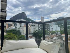 a bed on a balcony with a view of a mountain at Duas Suítes e o Cristo Redentor in Rio de Janeiro
