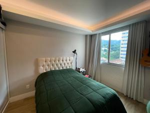 a bedroom with a bed and a large window at Duas Suítes e o Cristo Redentor in Rio de Janeiro