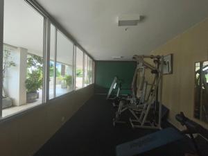 a room with a gym with a treadmill and windows at Duas Suítes e o Cristo Redentor in Rio de Janeiro