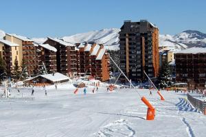 a group of people skiing in the snow in front of buildings at Studio idéalement situé à Ax les thermes in Ax-les-Thermes