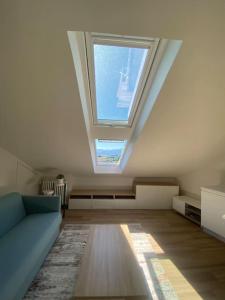 a living room with a skylight and a blue couch at Deliziosa mansarda con vista panoramica in Cuneo