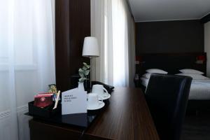 a hotel room with a table and a bed at Best Western Plus Plaza Hotel Graz in Graz