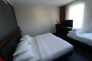a hotel room with two beds and a window at Best Western Plus Plaza Hotel Graz in Graz