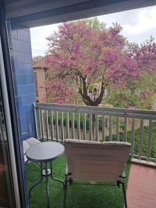 a table and a chair on a balcony with a tree at Casa Valadim in Chaves