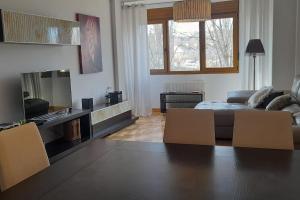 ein Wohnzimmer mit einem Sofa, einem Tisch und Stühlen in der Unterkunft Alojamiento Céntrico La Buganvilla in Aranda de Duero