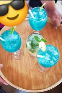 um grupo de três cocktails azuis numa mesa em Cabañas San Sebastian Palomino Beach Hostel em Palomino