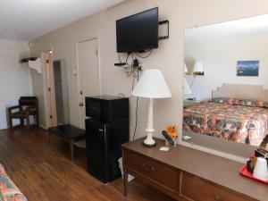 a hotel room with a bed and a tv on the wall at Royal Host Motel in Las Cruces