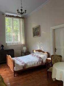 a bedroom with a bed and a chair and a window at Willa Starówka in Nałęczów