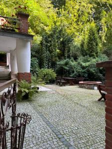 a garden with benches and a stone patio at Willa Starówka in Nałęczów