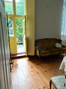 a living room with a couch and a wooden floor at Willa Starówka in Nałęczów