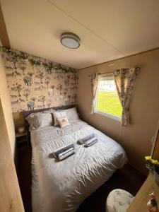 Un dormitorio con una cama con dos taburetes. en N and B caravan hire Flamingo Land, en Kirby Misperton