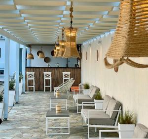 patio z białymi krzesłami, stołami i żyrandolami w obiekcie Charakas Horizon w mieście Gavrion