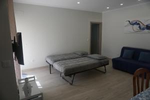 Un dormitorio con una cama y un sofá azul. en Sunny Home, en Amadora