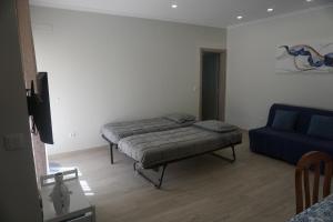 ein Schlafzimmer mit einem Bett und einem blauen Sofa in der Unterkunft Sunny Home in Amadora