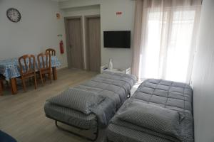ein Wohnzimmer mit einem Bett, einem Tisch und Stühlen in der Unterkunft Sunny Home in Amadora