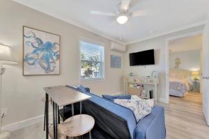 a living room with a blue couch and a bedroom at Sea Gem One bed one bath charmer steps to beach in Bradenton Beach