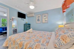 a bedroom with a bed and a blue wall at Sea Gem One bed one bath charmer steps to beach in Bradenton Beach