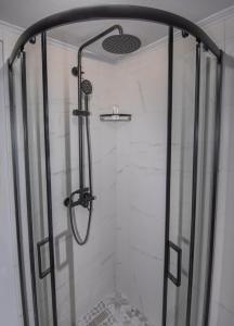 a shower with a glass shower door in a bathroom at Cozy Loft with Private Terrace in Kremasti