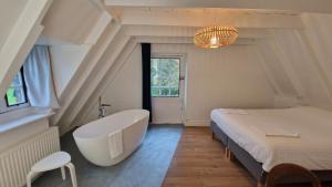 La salle de bains est pourvue d'une baignoire, d'un lit et d'une baignoire. dans l'établissement La Grange du Moulin de Lossulien, à Le Relecq-Kerhuon