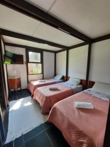 a room with two beds and a tv in it at Casa na Marina com piscina churrasqueira e píer in Guarujá +42 photos