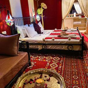 1 dormitorio con 2 camas y alfombra en Merzouga heart camp en Merzouga