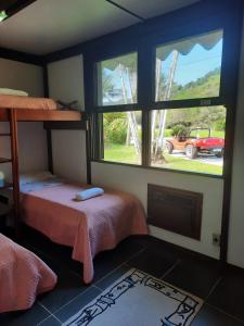 een kamer met 2 bedden en een raam met een vrachtwagen bij Casa Marina Guarujá in Guarujá
