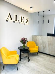 Alex Hotel في يريفان: كرسيين صفراء وطاولة في الغرفة