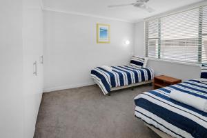 a bedroom with two beds and a window at Headland Gardens Holiday Apartments in Alexandra Headland