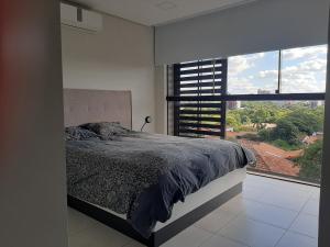 1 dormitorio con cama y ventana grande en Miradores del Chaco, en Asunción