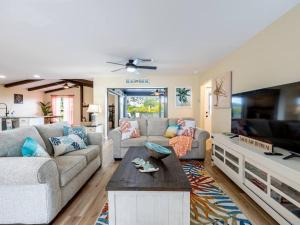 a living room with a couch and a tv at Englewood, Manasota Keys - 2 Bedroom Luxury Villa, Pool, Game room, 6 min to Beaches next to Canal in Englewood