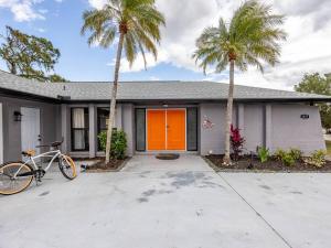 a bike parked in front of a house with palm trees at Englewood, Manasota Keys - 2 Bedroom Luxury Villa, Pool, Game room, 6 min to Beaches next to Canal in Englewood