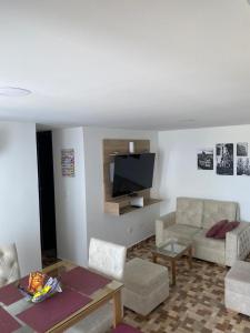 sala de estar con sofá y TV en Lujoso apartamento amoblado en Coveñas cerca a la playa, en Coveñas