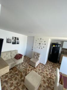 uma sala de estar com um sofá, uma mesa e cadeiras em Lujoso apartamento amoblado en Coveñas cerca a la playa em Coveñas