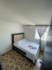 um quarto com uma cama e uma janela em Lujoso apartamento amoblado en Coveñas cerca a la playa em Coveñas