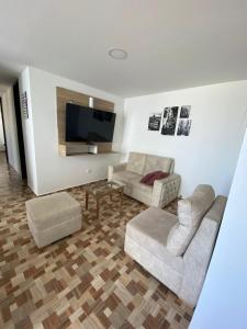 uma sala de estar com 2 sofás e uma televisão de ecrã plano em Lujoso apartamento amoblado en Coveñas cerca a la playa em Coveñas