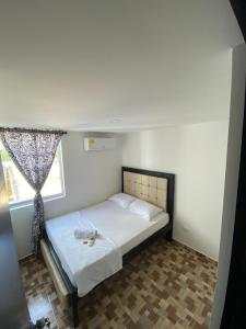um quarto com uma cama num quarto com uma janela em Lujoso apartamento amoblado en Coveñas cerca a la playa em Coveñas