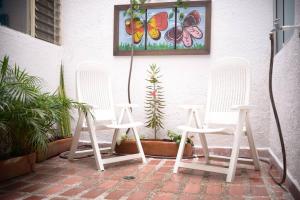 two white chairs sitting on a patio with plants at Nogales in Medellín