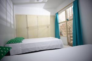 Un dormitorio con 2 camas y una ventana con en Nogales, en Medellín