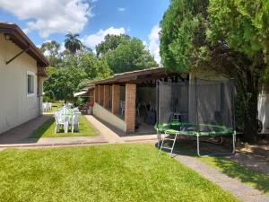 un patio con mesa y sillas en el césped en Chácara PALOMA en Jaguariúna