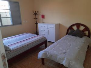 um quarto com 2 camas individuais e uma cómoda em Chácara PALOMA em Jaguariúna