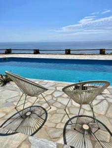 two chairs sitting next to a swimming pool at Charakas Horizon in Gavrion