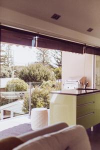 a kitchen with a view of a large window at Sumner Surf Break Apt 3 in Christchurch