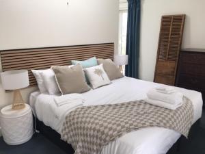 a bedroom with a large white bed with pillows at Sumner Surf Break Apt 3 in Christchurch