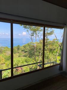 a window in a room with a view of the ocean at Nido Aracari in San Pedrillo +20 photos