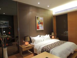 1 dormitorio con 1 cama grande en una habitación de hotel en SLD-Yicen INTERNATIONAL SERVICE APARTMENT, en Guangzhou