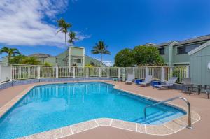 a swimming pool with two chairs and a fence at Newly renovated, airy, spacious with ocean view in Princeville