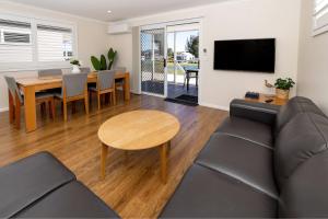 a living room with a couch and a table at BIG4 River Myall Holiday Resort in Bulahdelah